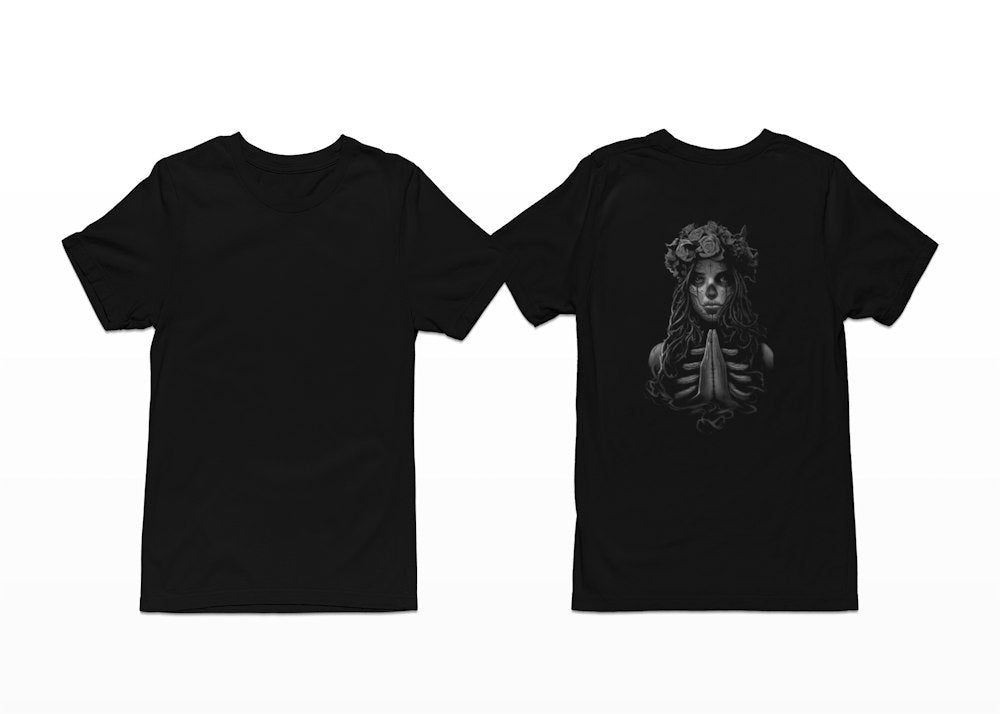 A girl prays, wearing a rose crown and in Day of the Dead Sugar Skull make-up on this tee. Shortsleeve - Back Print.
